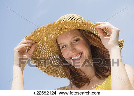 Portrait of woman wearing straw hat View Large Photo Image Picture - Portrait of woman wearing straw hat. Fotosearch