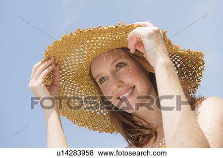 Stock Photo - Portrait of woman wearing straw hat. Fotosearch