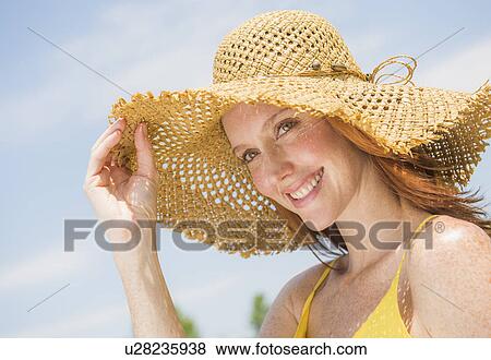 Stock Photo - Portrait of woman wearing straw hat. Fotosearch
