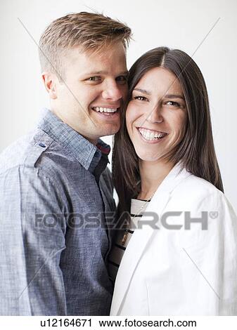 Stock Image - Portrait of young couple, studio shot. Fotosearch