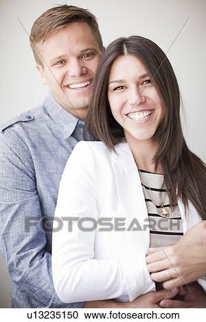 Stock Image - Portrait of young couple, studio shot. Fotosearch