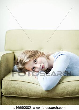 Portrait of young woman lying on sofa View Large Photo Image Stock Image - Portrait of young woman lying on sofa. Fotosearch