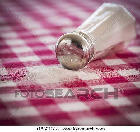 Stock Photo - Salt shaker on checked tablecloth. Fotosearch