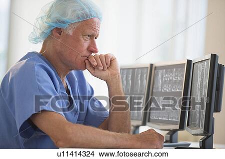 Picture - Senior surgeon working on computer. Fotosearch