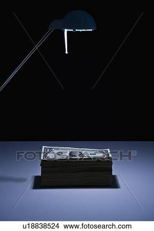 Stack Of Dollars Under Desk Lamp Picture U18838524 Fotosearch