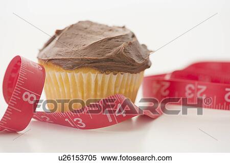 Stock Photography - Studio Shot of cupcake and tape measure. Fotosearch