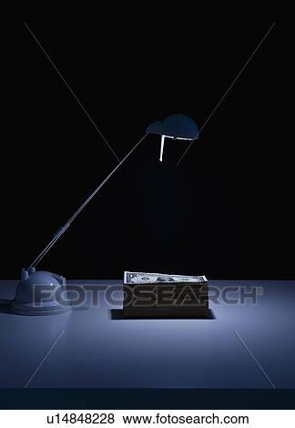 Studio shot of desk lamp and stack of dollar bills View Large Photo Image Stock Photo - Studio shot of desk lamp and stack of dollar bills. Fotosearch