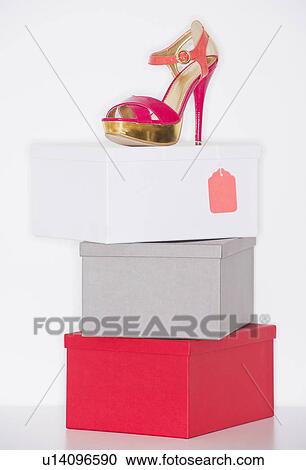 Stock Image - Studio shot of dress shoe on top of stack of boxes. Fotosearch