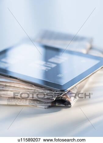 Stock Photo - Studio shot of newspaper and tablet PC. Fotosearch