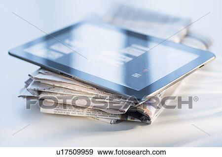 Studio shot of newspaper and tablet PC View Large Photo Image Stock Photo - Studio shot of newspaper and tablet PC. Fotosearch