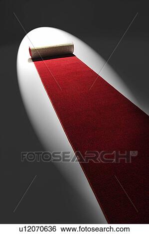 Stock Photograph - Studio shot of rolling out red carpet. Fotosearch