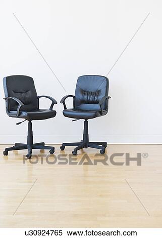 Stock Photography - Studio shot of two black office chairs. Fotosearch