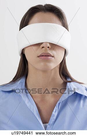 Stock Image - Studio shot of woman wearing blindfold. Fotosearch