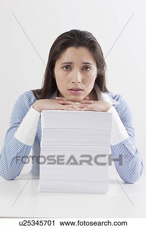 Stock Image - Studio shot of woman with stack of documents. Fotosearch