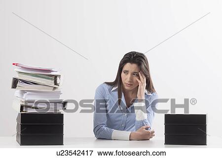 Stock Photo - Studio shot of woman with stack of documents. Fotosearch