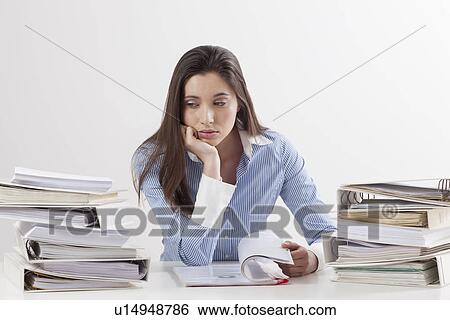 Studio shot of woman with stack of documents View Large Photo Image Stock Photograph - Studio shot of woman with stack of documents. Fotosearch