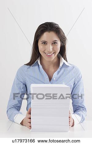 Stock Photograph - Studio shot of woman with stack of documents. Fotosearch