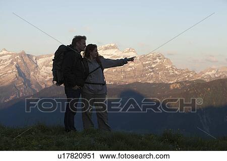 Stock Image - Switzerland, Leysin, Hikers looking at view of Alps. Fotosearch