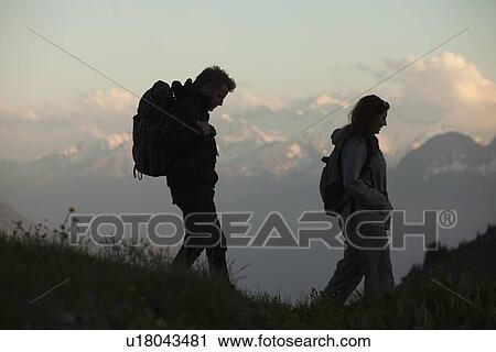 Stock Image - Switzerland, Leysin, Hikers marching through Alpine landscape. Fotosearch