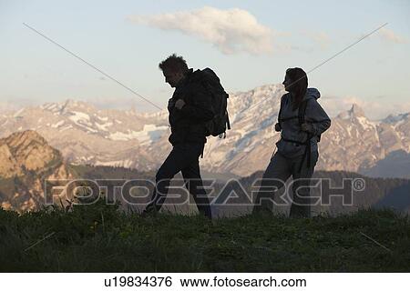 Stock Photograph - Switzerland, Leysin, Hikers marching through Alpine landscape. Fotosearch