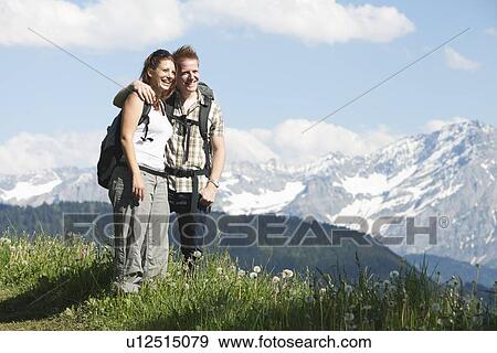 Stock Photo - Switzerland, Leysin, Hikers standing on meadow in Alps. Fotosearch