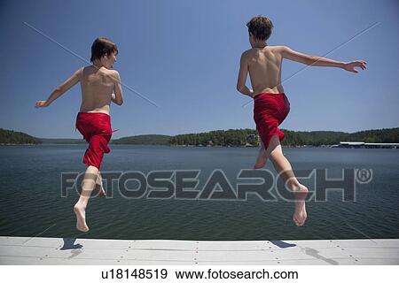 USA, Arkansas, Murfreesboro, Two brothers (8-9, 12-13) jumping into water View Large Photo Image Stock Photo - USA, Arkansas, Murfreesboro, Two brothers (8-9, 12-13) jumping into water. Fotosearch