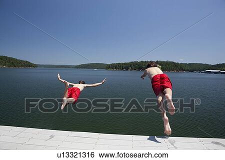 USA, Arkansas, Murfreesboro, Two brothers (8-9, 12-13) jumping into water View Large Photo Image Stock Photograph - USA, Arkansas, Murfreesboro, Two brothers (8-9, 12-13) jumping into water. Fotosearch