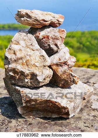 Stock Image - USA, Maine, Camden, Pile of stones and scenic coastline . Fotosearch