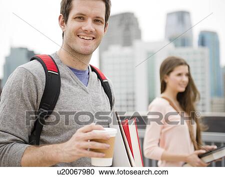 Stock Image - USA, New Jersey, Jersey City, Couple of students in city. Fotosearch