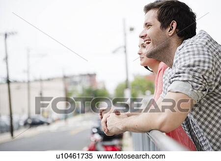 USA, New Jersey, Jersey City, Profile of happy young couple leaning on fence View Large Photo Image Stock Photography - USA, New Jersey, Jersey City, Profile of happy young couple leaning on fence. Fotosearch