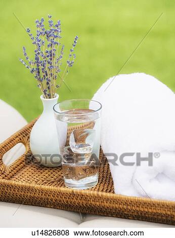 Stock Photo - Wattle tray with glass of water, towel and lavender. Fotosearch