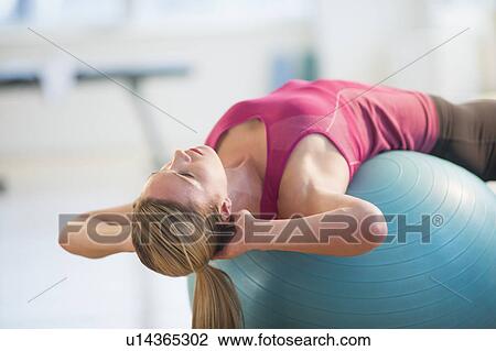 Stock Image - Woman exercising on fitness ball. Fotosearch
