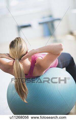 Stock Photograph - Woman exercising on fitness ball. Fotosearch