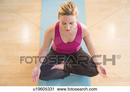Stock Image - Woman exercising on mat. Fotosearch