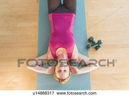 Stock Photo - Woman exercising on mat. Fotosearch