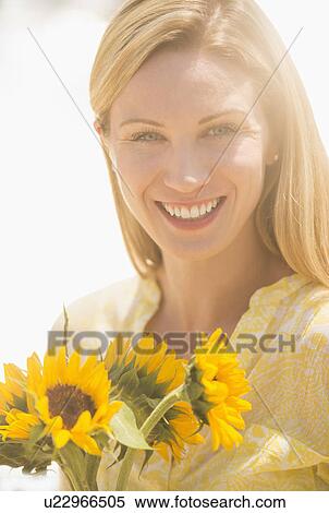 Woman holding sunflowers View Large Photo Image Stock Photography - Woman holding sunflowers. Fotosearch