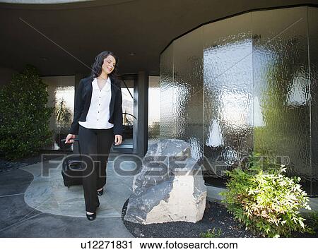 Woman leaving house with piece of luggage View Large Photo Image Stock Image - Woman leaving house with piece of luggage. Fotosearch