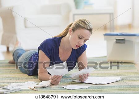 Woman looking at bills View Large Photo Image Stock Image - Woman looking at bills. Fotosearch