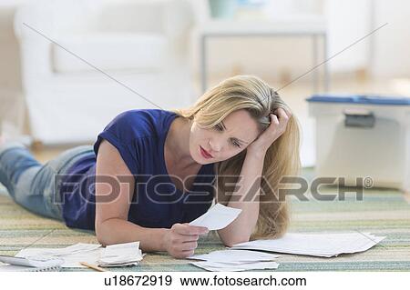 Woman looking at bills View Large Photo Image Stock Photo - Woman looking at bills. Fotosearch