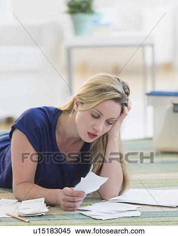 Stock Photography - Woman looking at bills. Fotosearch