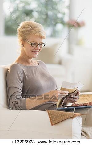 Stock Photo - Woman looking at textile swatches. Fotosearch