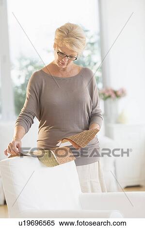 Stock Photography - Woman looking at textile swatches. Fotosearch