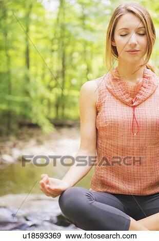 Woman practicing joga in forest View Large Photo Image Stock Photo - Woman practicing joga in forest. Fotosearch