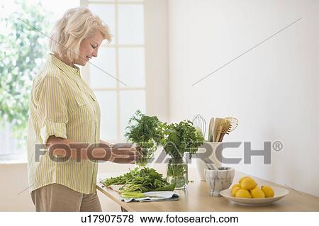 Woman preparing food in kitchen View Large Photo Image Stock Photo - Woman preparing food in kitchen. Fotosearch