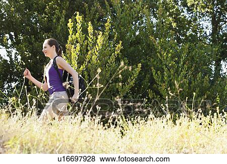 Woman running through meadow View Large Photo Image Stock Photo - Woman running through meadow. Fotosearch