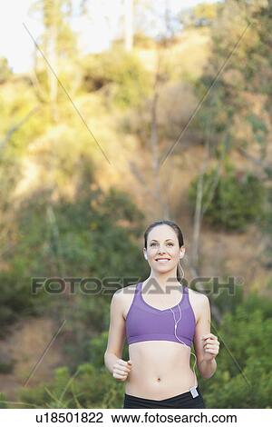 Woman running with headphones on View Large Photo Image Stock Image - Woman running with headphones on. Fotosearch