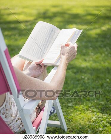 Woman sitting on deck chair and reading book View Large Photo Image Stock Photo - Woman sitting on deck chair and reading book. Fotosearch