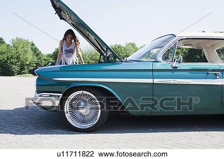 Woman standing near broken vintage car View Large Photo Image Stock Image - Woman standing near broken vintage car. Fotosearch