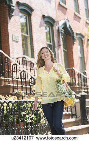 Stock Photo - Woman walking in street. Fotosearch