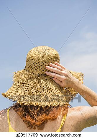 Stock Photo - Woman wearing straw hat. Fotosearch
